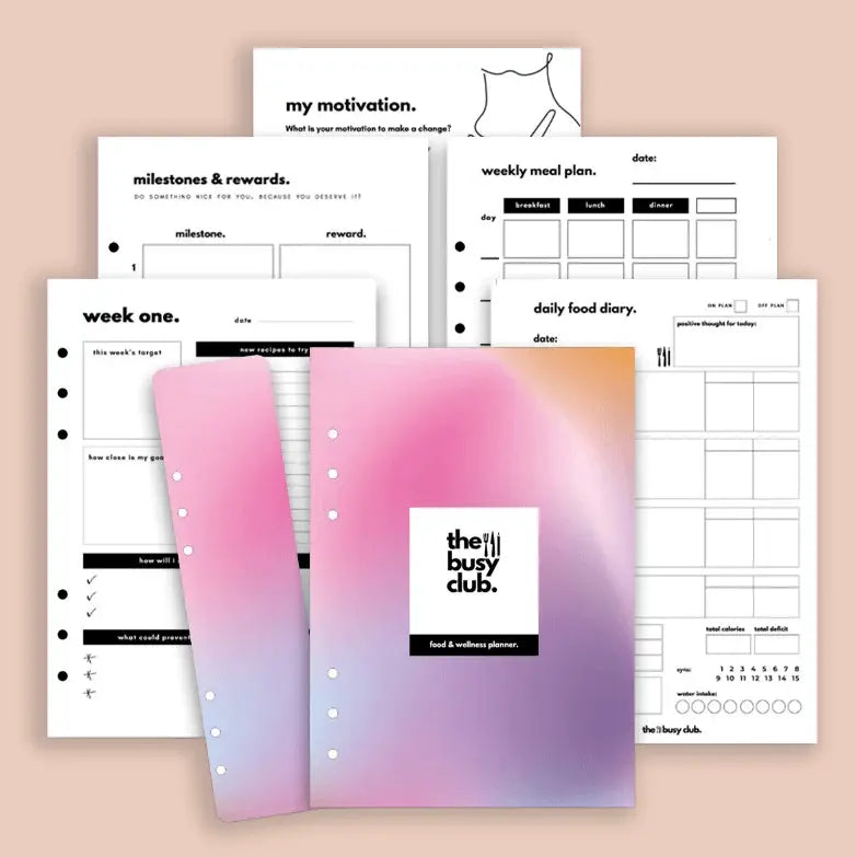 Planners with various sections and a pink and purple cover labeled 'the busy club' on a beige background.