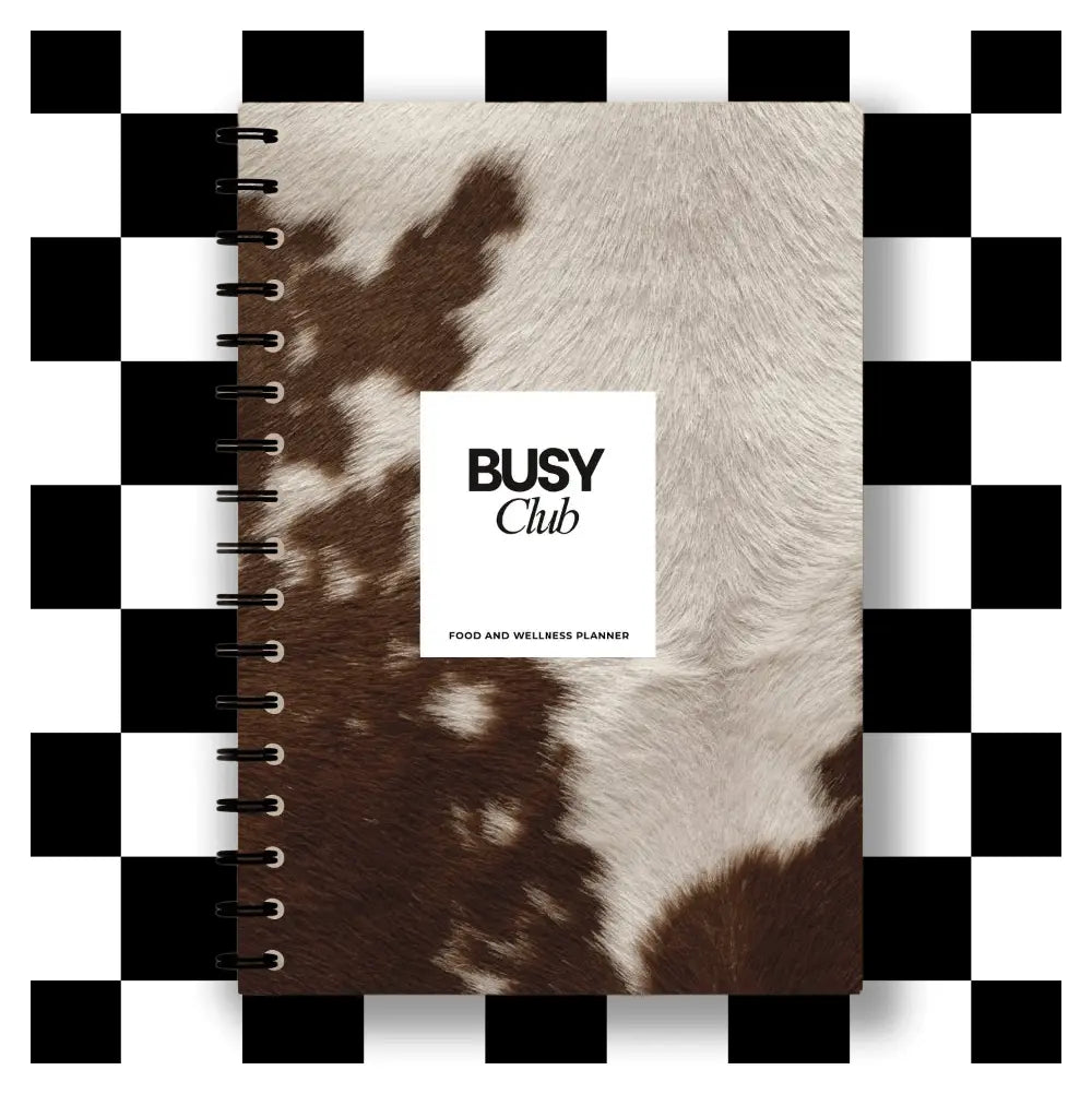 Notebook with cowhide texture and 'Busy Club' label on a checkered border