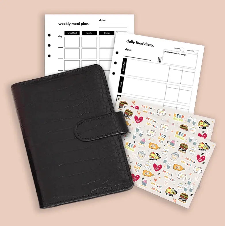 Black planner with weekly meal plan, daily food diary, and decorative stickers on a beige background