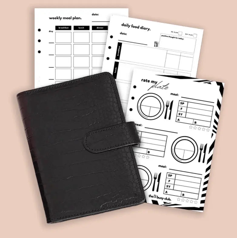 Black planner with weekly meal plan and daily food diary sheets on a beige background