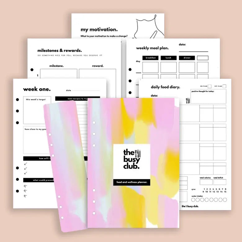 Planners with various pages and a colorful cover on a beige background