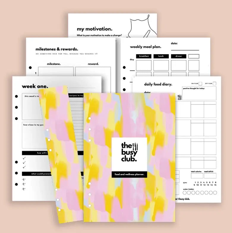 Planner with colorful cover and various pages on a beige background