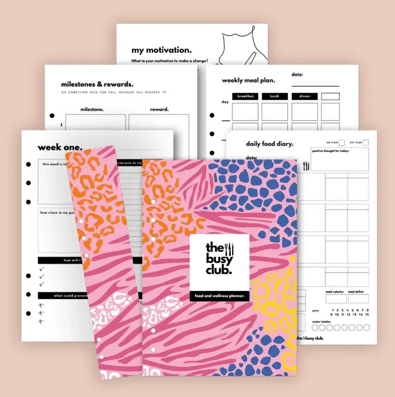 Planner with colorful cover and various pages on a beige background