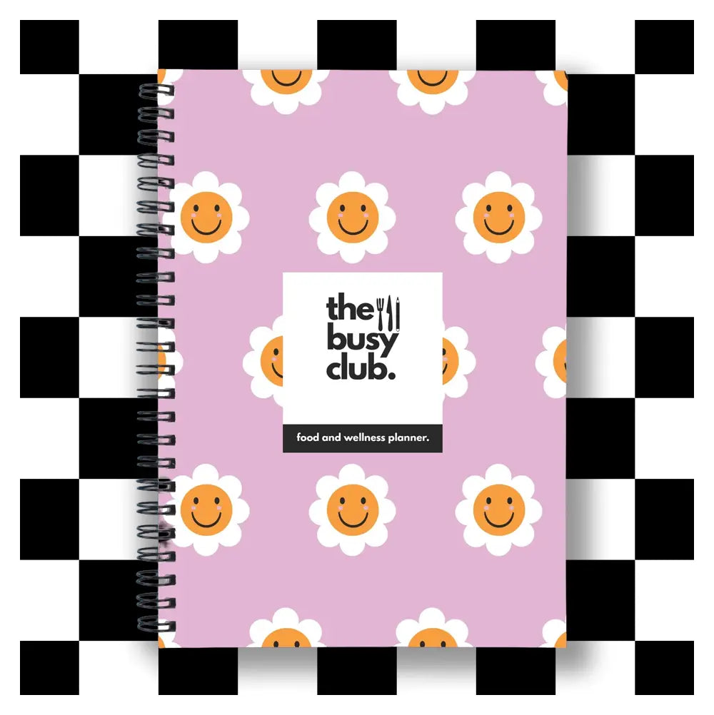 Planner with smiley face design and 'the busy club' branding on a checkered border.
