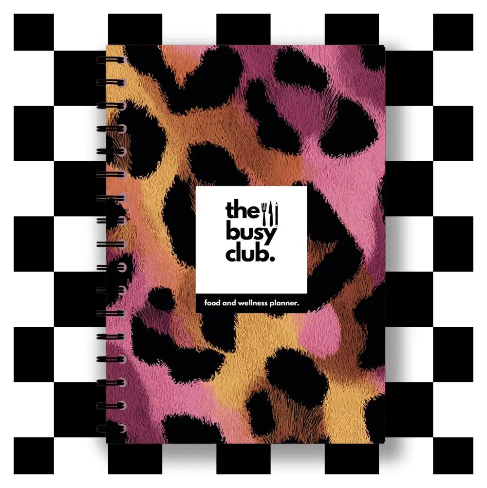 Leopard print planner with 'the busy club' logo on a checkered background
